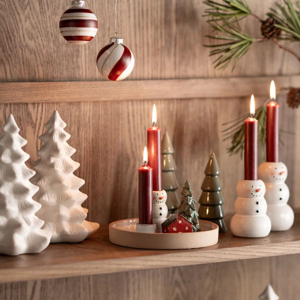 escena navideña invernal con velas y figuras de cerámica