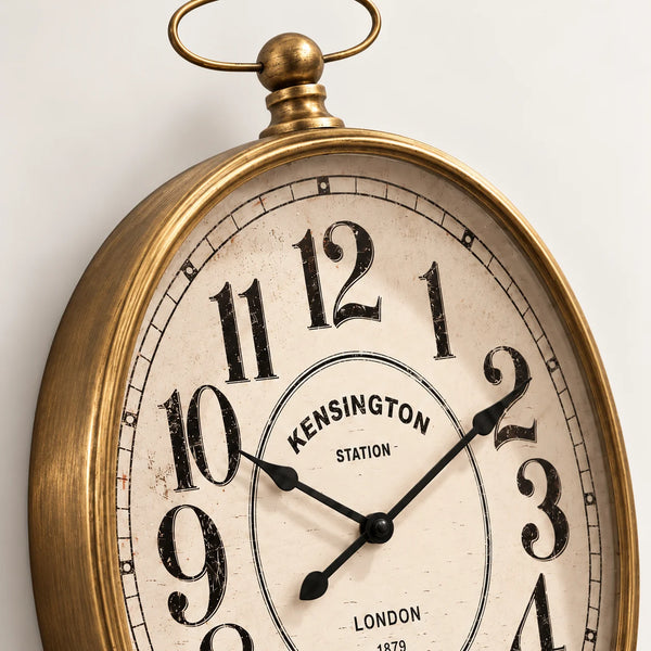Detalle del Reloj Kensington Station con marco dorado envejecido, esfera retro y números negros.