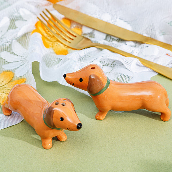 Salero y pimentero en forma de perro salchicha sobre mesa decorada vintage