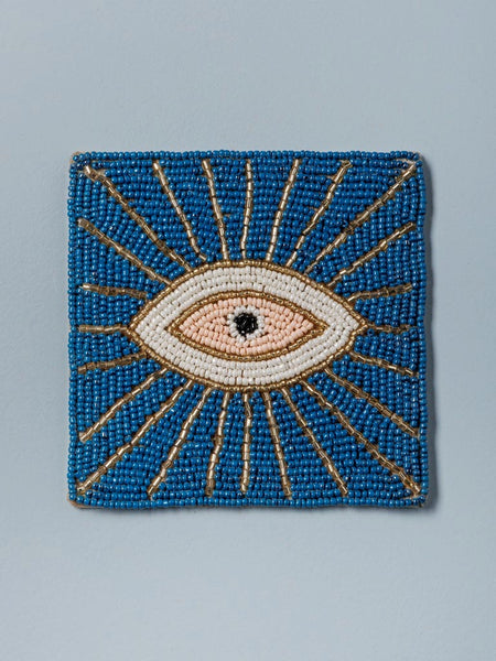 Posavaso azul con rayos dorados y ojo central