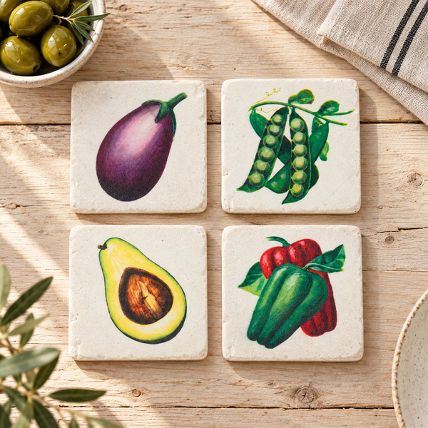 Set de cuatro posavasos vegetales vintage sobre mesa de madera junto a aceitunas y vajilla.