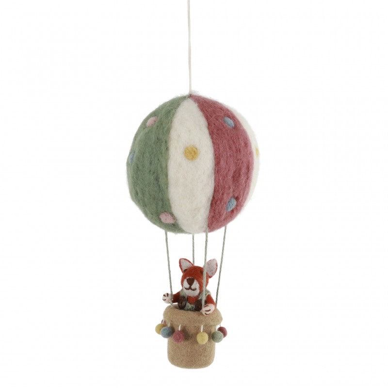 Colgante artesanal de zorro en globo aerostático hecho de lana de Nueva Zelanda, producido a mano por mujeres en Nepal, ideal para decoración infantil y sostenible.
